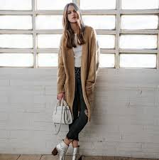 Cardigan beige con borsa argentata e stivali abbinati