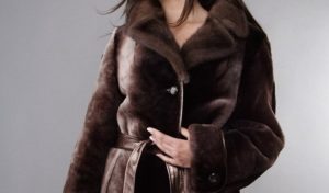 batang babae sa isang mouton fur coat