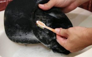 cleaning a cap with a toothbrush