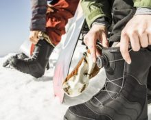 zieht Snowboardstiefel an