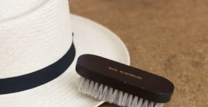 cleaning a hat with a brush