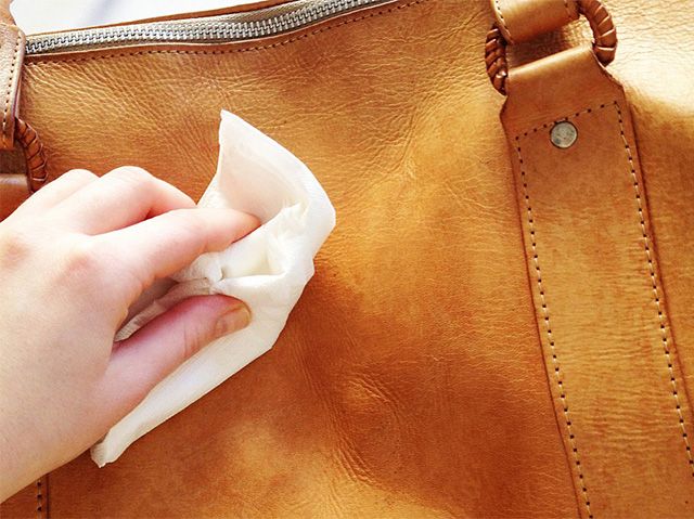 Cleaning the bag with a damp cloth with cream