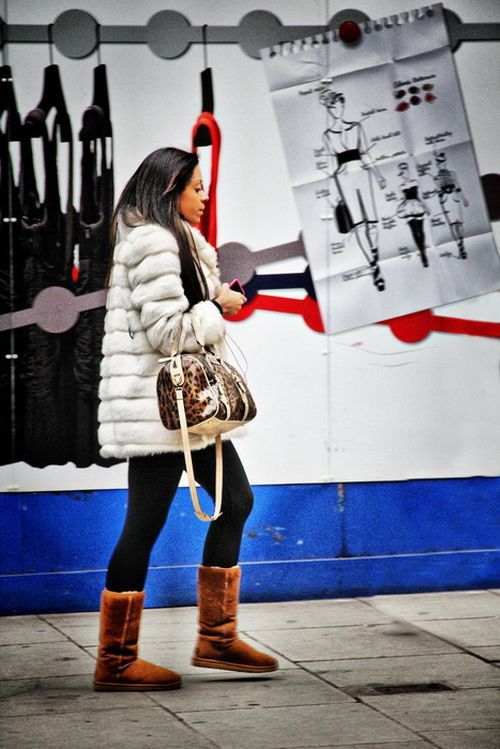 botas ugg debajo de un abrigo de piel blanco