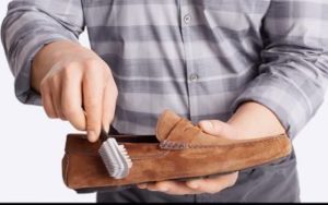 hombre limpiando mocasines de gamuza