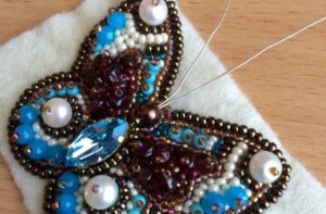 shape the head by sewing a large bead to the last of the beads lining the outline of the brooch