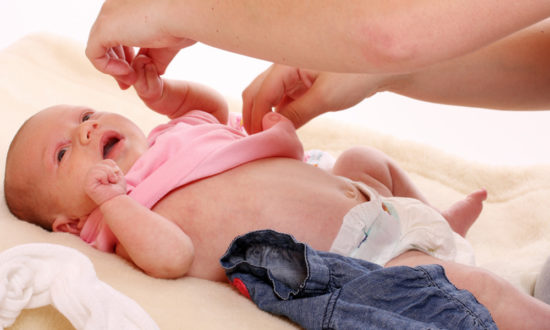 removing the bodysuit from a newborn