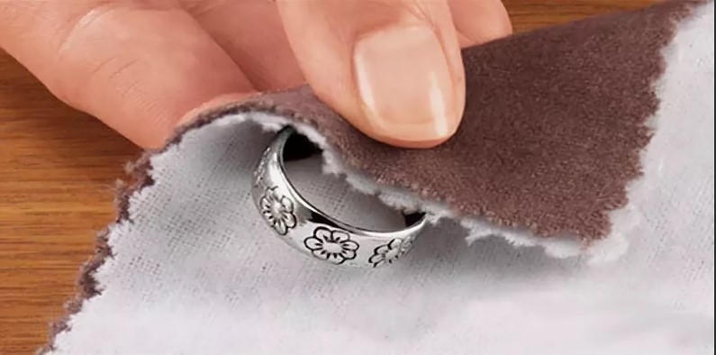 een zilveren ring schoonmaken met een wollen doek