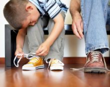 niño atando sus zapatillas