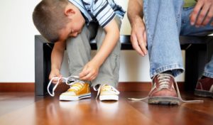 niño atando sus zapatillas