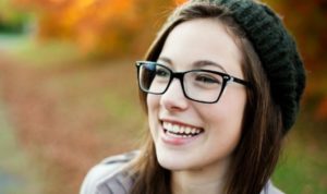 girl with glasses laughs