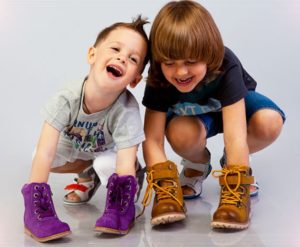 niños con zapatos en las manos