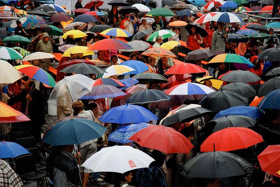 crowd under umbrellas