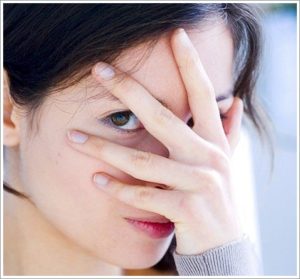 girl closes her eyes with her hand