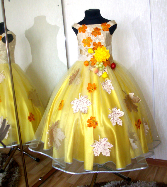 Vestido amarillo adornado con hojas de cartón.