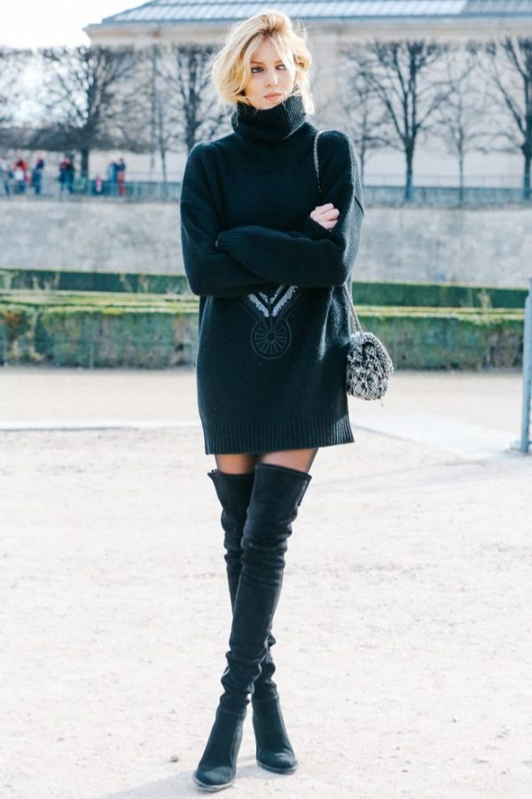 Des bottes noires avec un pull volumineux.