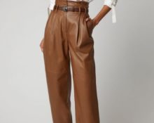 Pantaloni in pelle marrone con camicetta bianca.