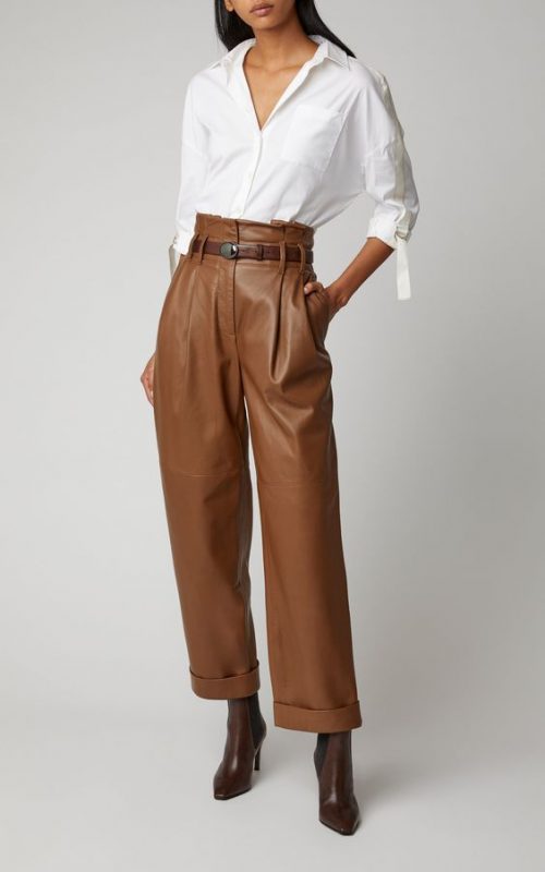 Pantalons de pell marró amb una brusa blanca.