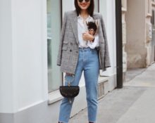 Chaqueta de cuadros gris, camisa holgada blanca y jeans rectos.